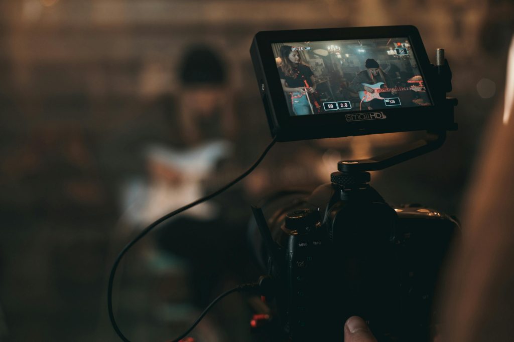 pexels photo 2510428 2510428 A cinematic close-up of filming a rock band performance with focus on camera screen.